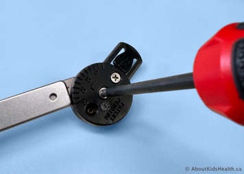 Tightening the top screw on the bar using a screwdriver