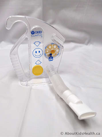 Incentive spirometer has a tube to breathe into, handle on the side, yellow circle inside, and smiley face printed on front
