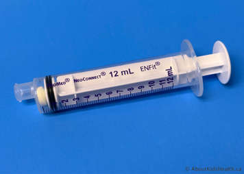 Marcaptopurine tablet inside oral syringe with the plunger pushing the tablet flush against the front of the syringe