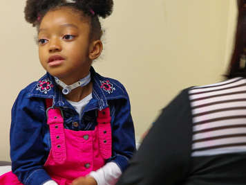 Child with a tracheostomy sitting comfortably.