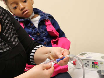 Slowly pull a tracheostomy suction catheter from its package