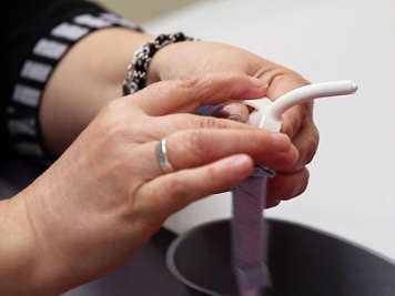 Using the flanges to hold and insert a tracheostomy tube