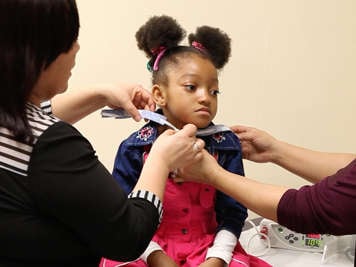 Placing tracheostomy ties around a child’s neck