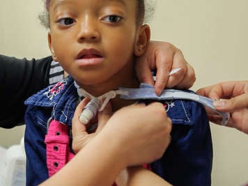 Unfastening Velcro tracheostomy tube ties.
