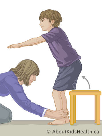 Enfant se mettant debout d’un tabouret lorsque son parent tient ses chevilles