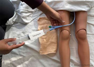 tobramycin mixture syringe at opening of catheter