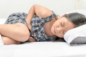 Girl lying down holding abdomen