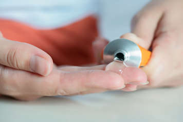 Person squeezing tube of muscle cream into hand