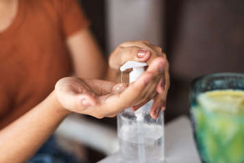 Person pumping hand sanitizer into their hand