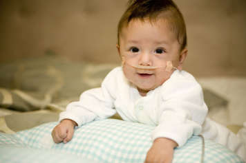 Baby showing tummy time over a breastfeeding pillow