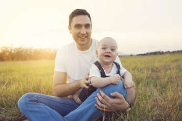 Father with baby showing tummy time on his lap