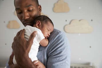 Father carrying baby on his chest