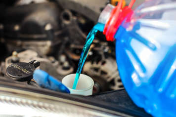 Windshield washer fluid being poured into engine