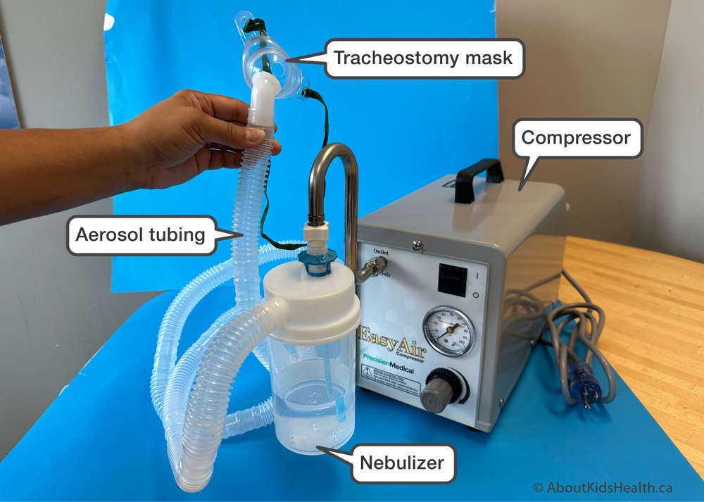 Heavy-duty compressor with water bottle and corrugated tubing connected to a tracheostomy mask