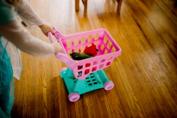 Child pushing toy shopping cart