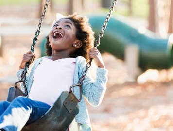 Girl laughing on swing