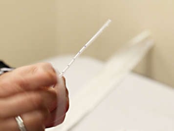 Person holding the suction catheter four to six inches from the end