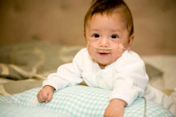 Baby showing tummy time over a breastfeeding pillow